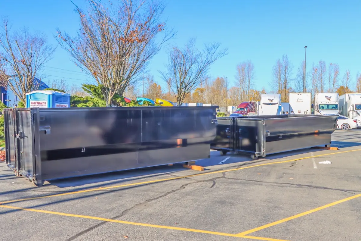 Professional dumpster rental service with roll-off container on residential driveway in Oak Harbor